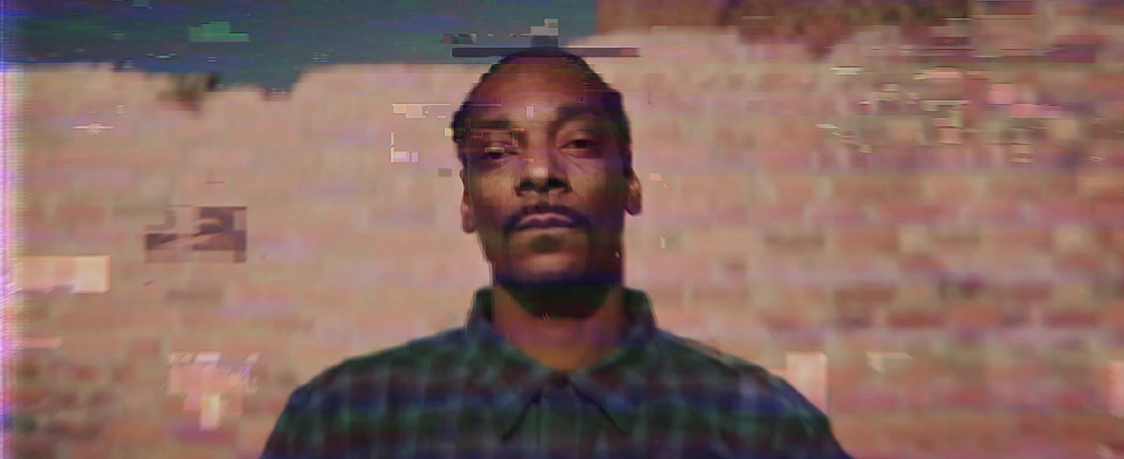 a man standing in front of a brick wall