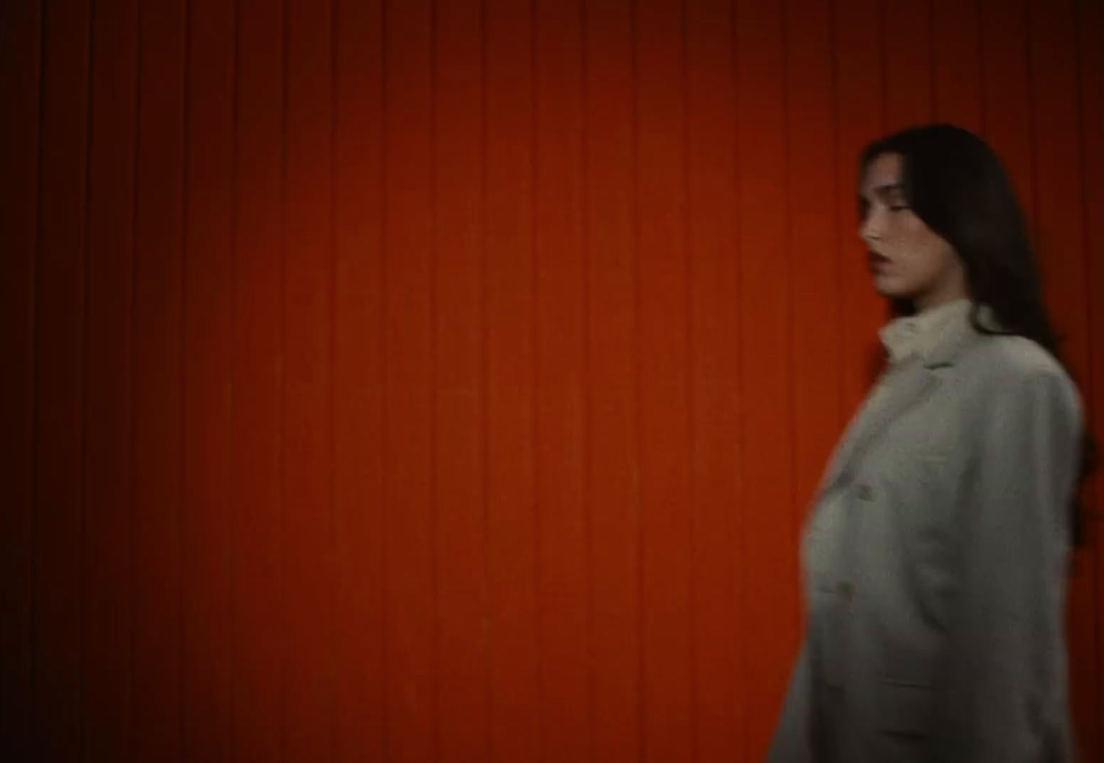 a woman standing in front of a red wall