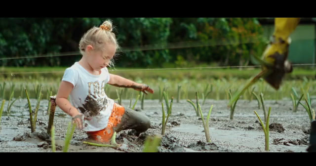 a little girl is playing in the mud