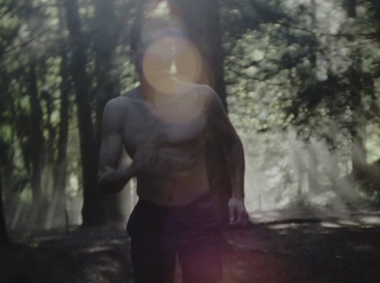 a man standing in the woods with a frisbee