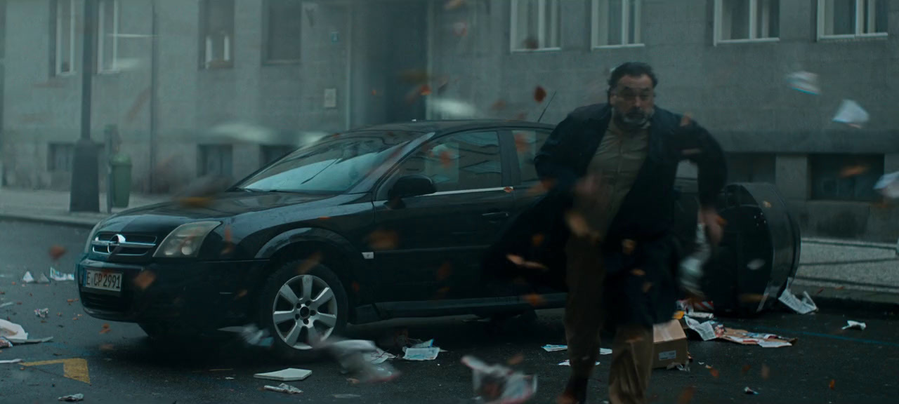 a man standing next to a car on a street