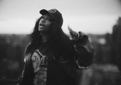 a woman with long hair wearing a baseball cap