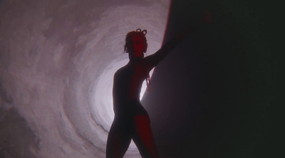 a woman in a bodysuit standing in a tunnel