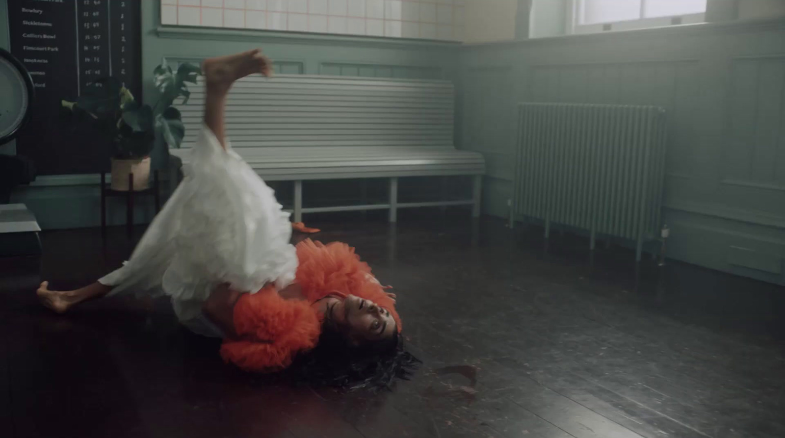 a woman in a white dress laying on the floor