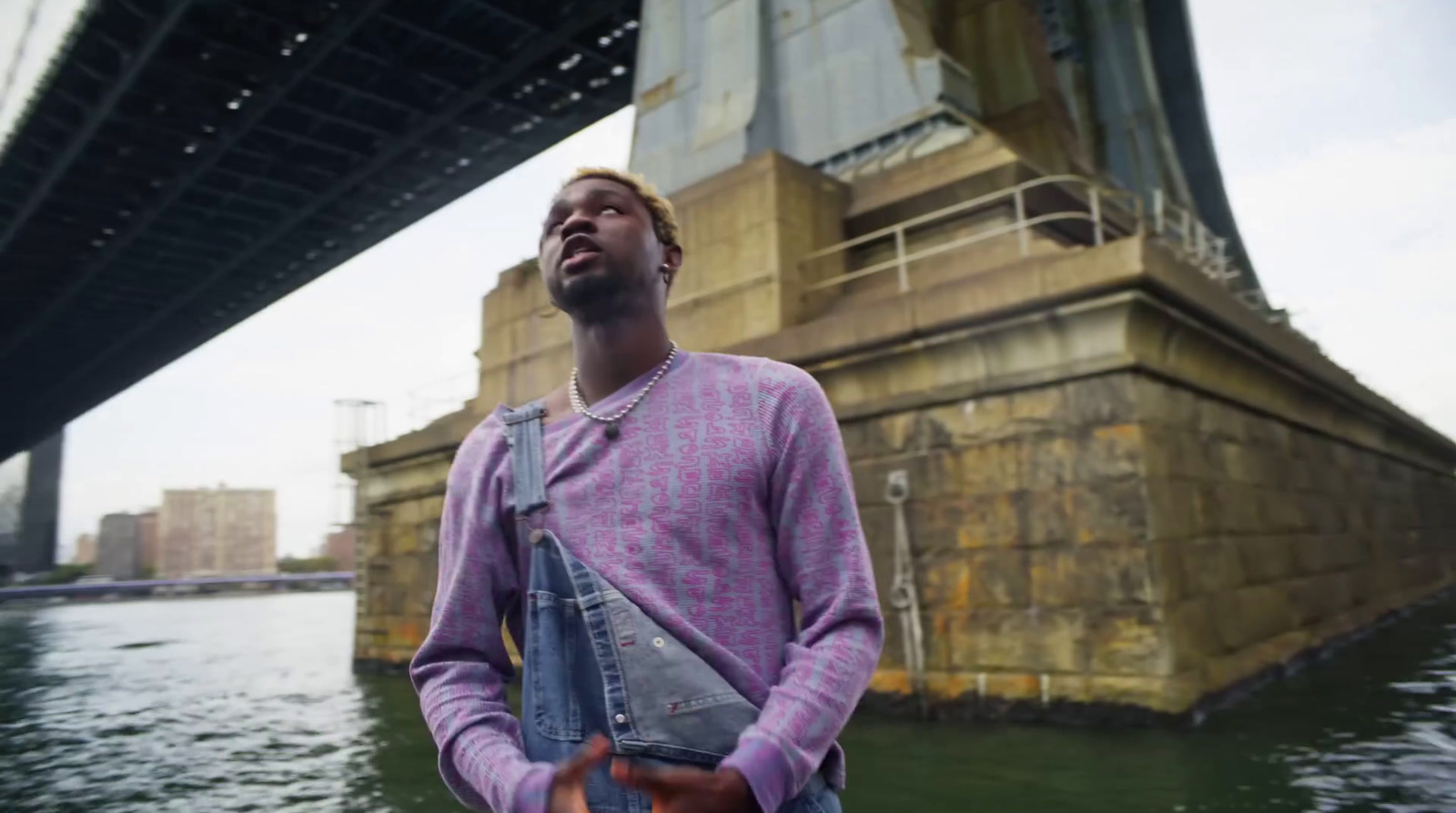 a man standing in front of a bridge