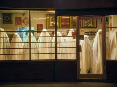 a row of white ghost costumes in a store window