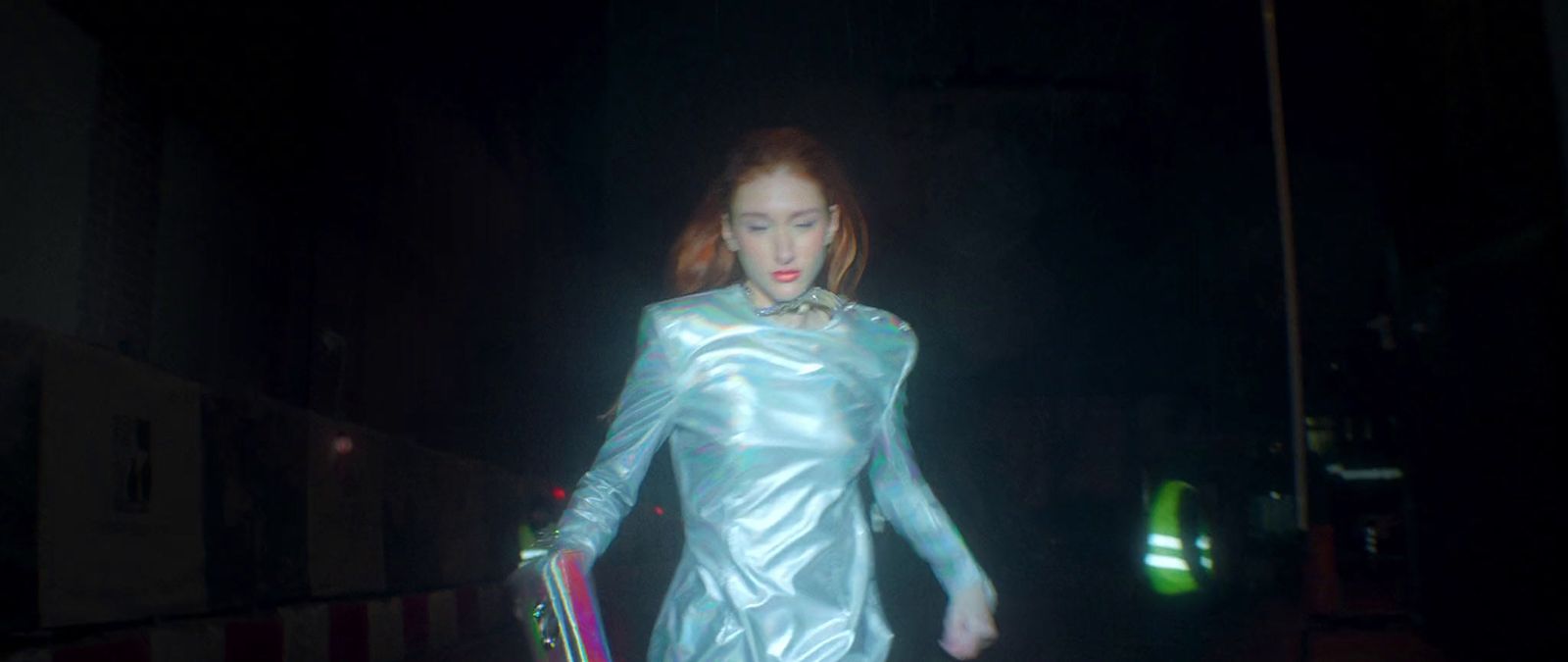 a woman in a silver dress holding a skateboard