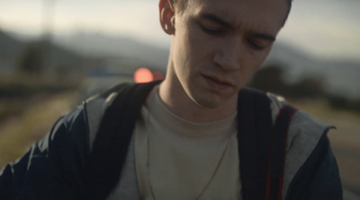 a young man looking down at his cell phone