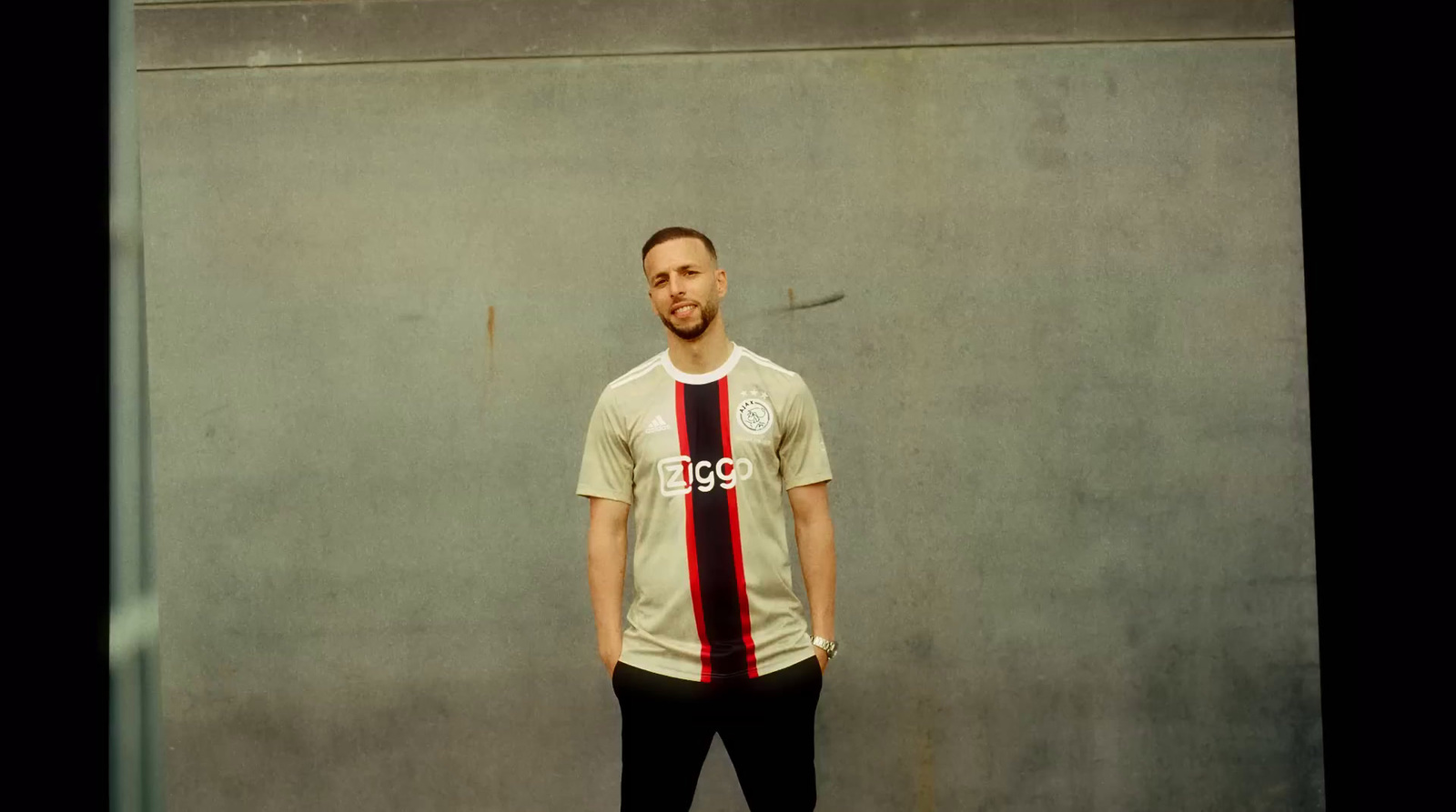 a man standing in front of a cement wall