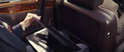 a person sitting in a car using a laptop computer