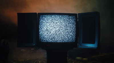 an old tv sitting on top of a black pole