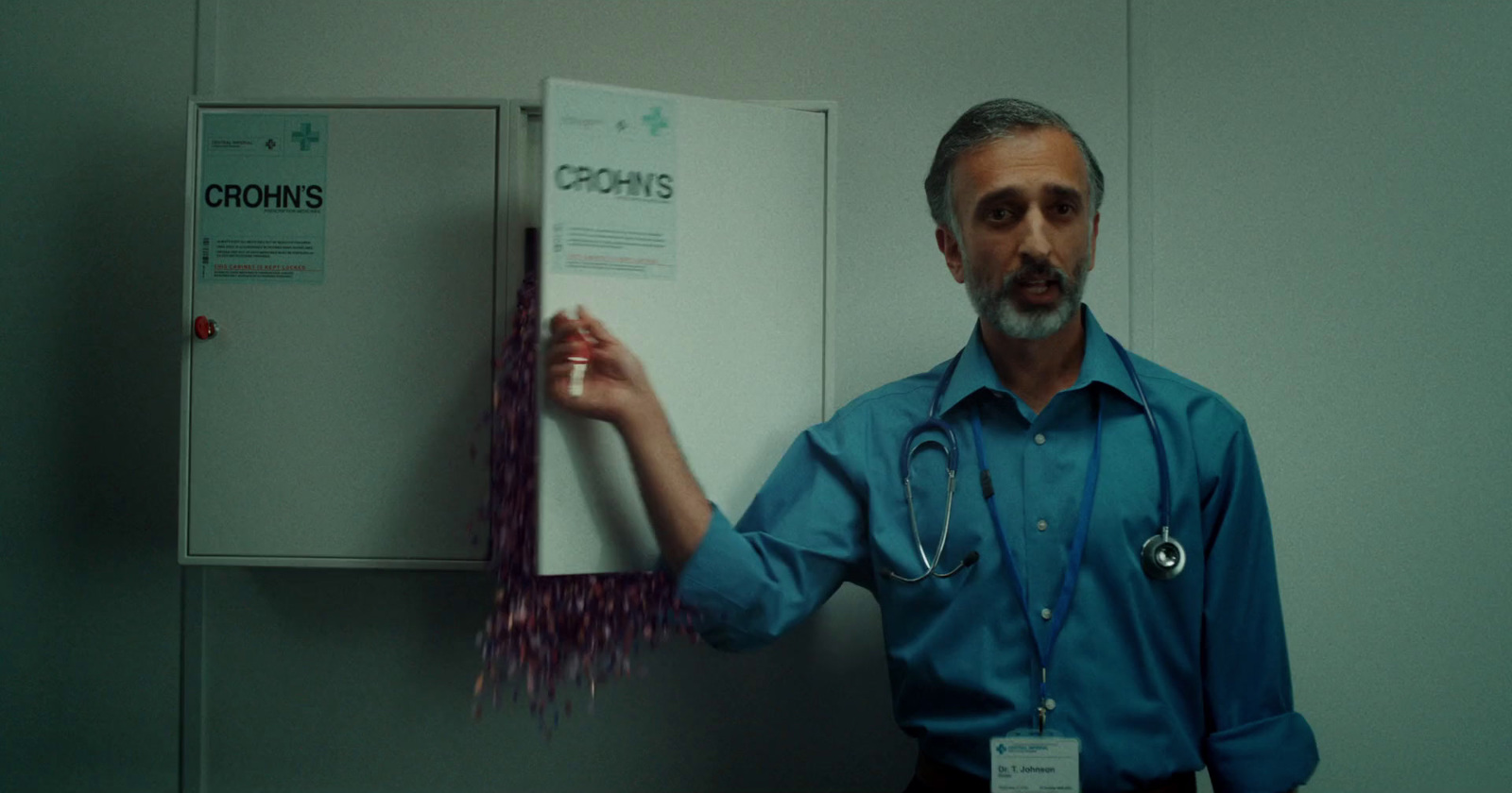 a man with a stethoscope standing next to a cabinet