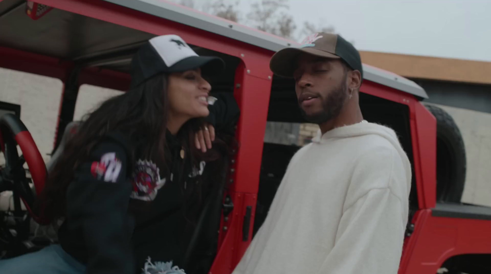 a man and a woman standing next to a red truck