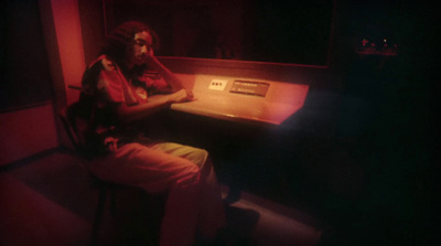 a man sitting at a desk in a dark room