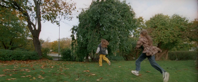 two young girls playing with a frisbee in a yard