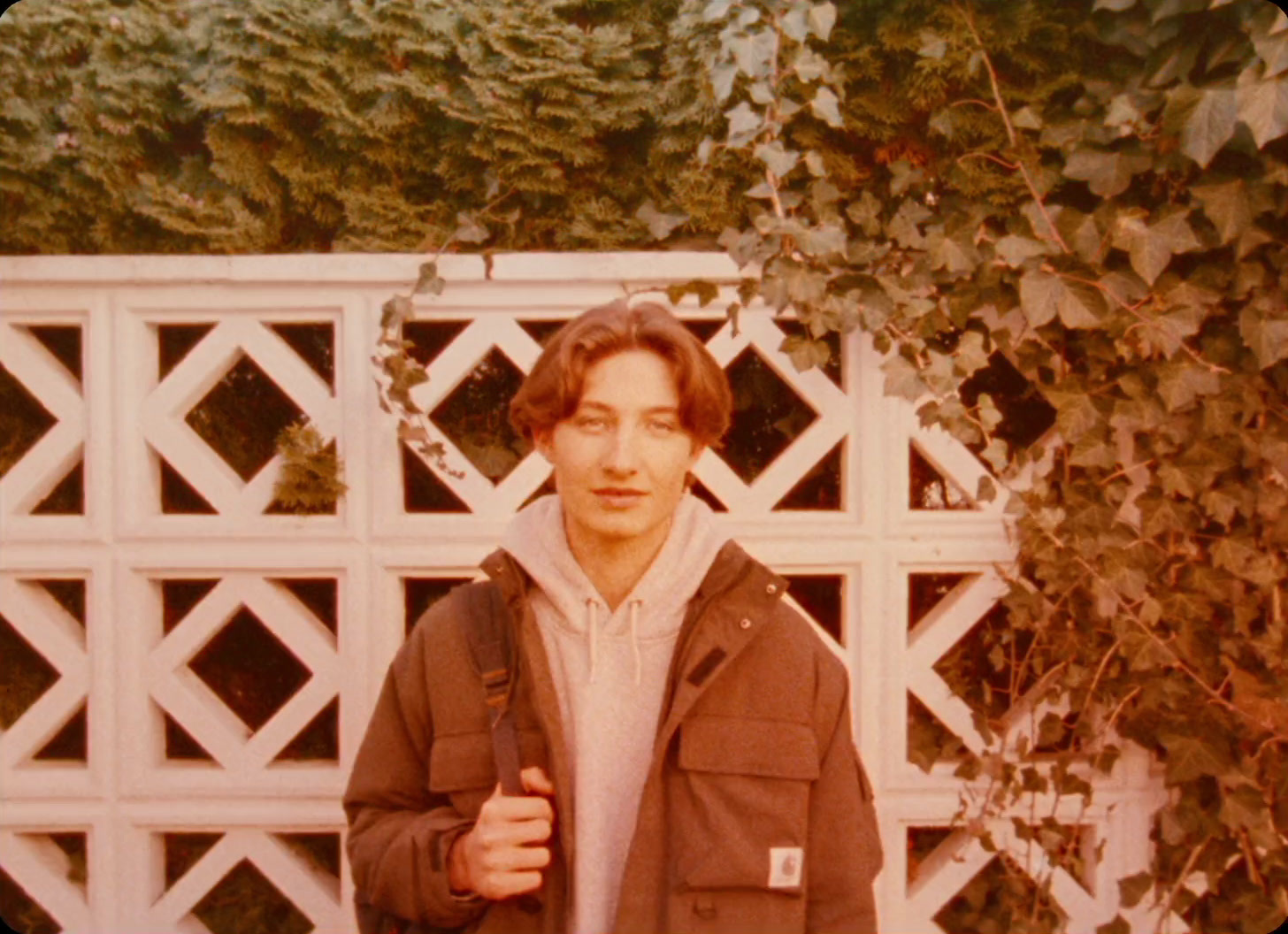 a man standing in front of a white fence