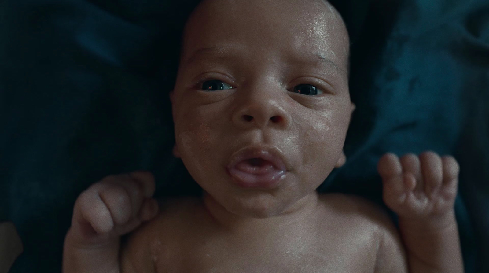 a close up of a baby laying on a blanket