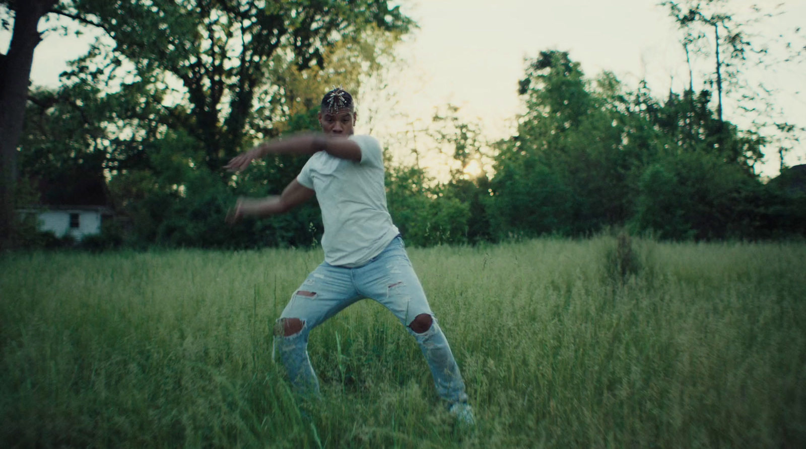 a man standing in a field holding a frisbee