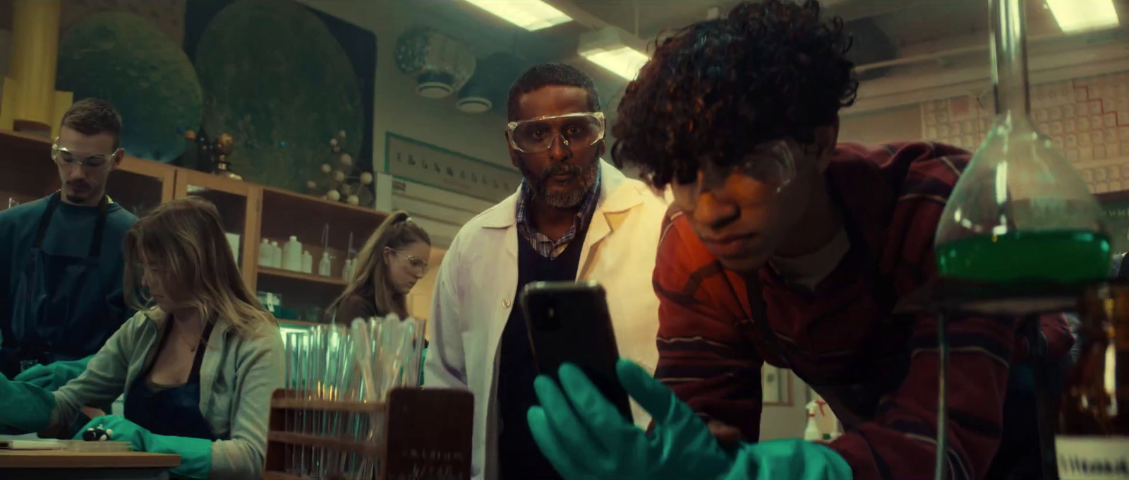 a group of people in a lab looking at something on a tablet