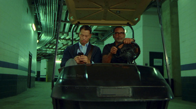 two men looking at a cell phone in a vehicle