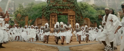 a group of people dressed in white walking down a street