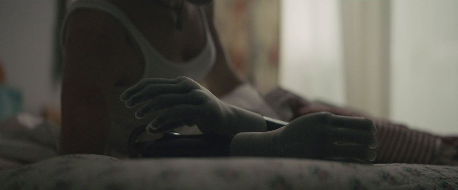 a woman sitting on a bed holding a remote control