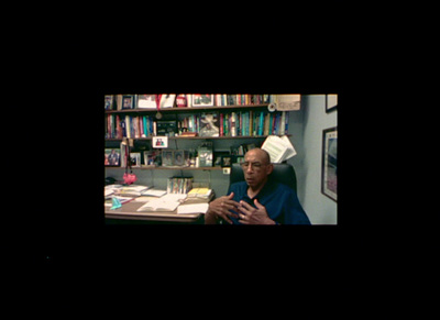 a man sitting at a desk in front of a bookshelf