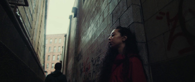 a woman standing next to a brick wall