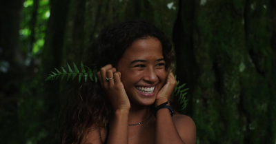 a woman smiling in front of a tree