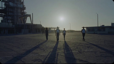 a group of people walking across a parking lot