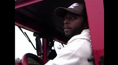 a man in a white hoodie driving a red truck