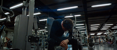 a man sitting on a bench in a gym