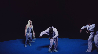 a group of people standing on top of a blue floor