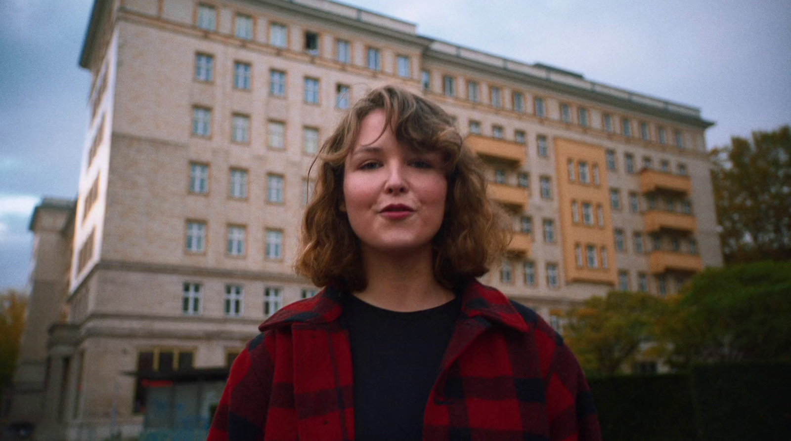 a woman standing in front of a tall building