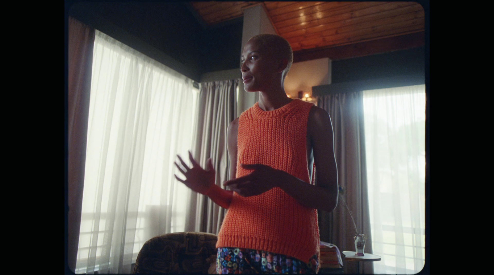 a woman standing in front of a window with her hands out