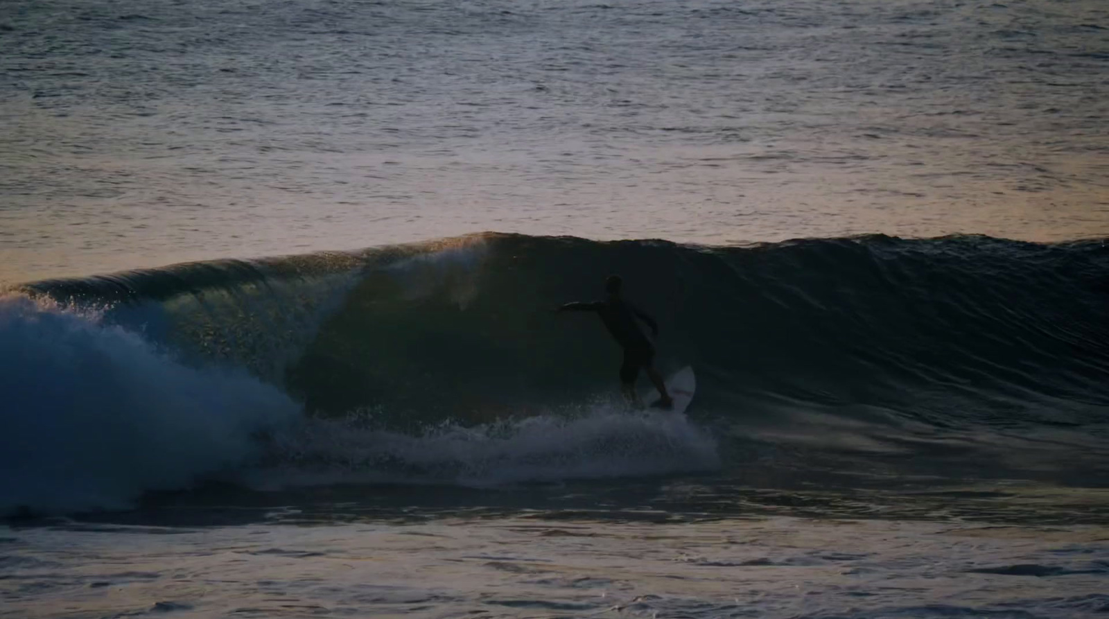 a man riding a wave on top of a surfboard