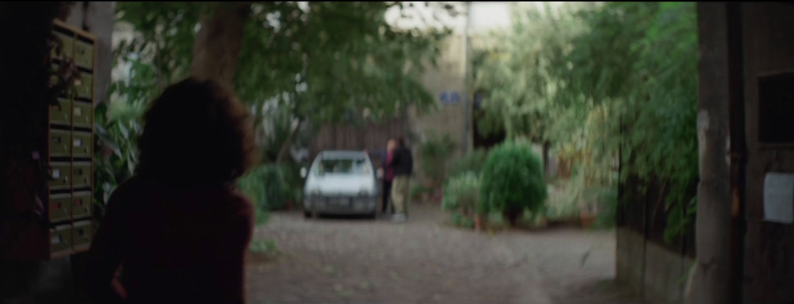 a woman standing in front of a car on a street