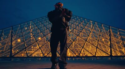 a man standing in front of a pyramid at night