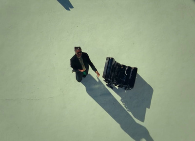 a man is walking with a suitcase in his hand