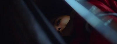 a person in a red hoodie looking out of a window