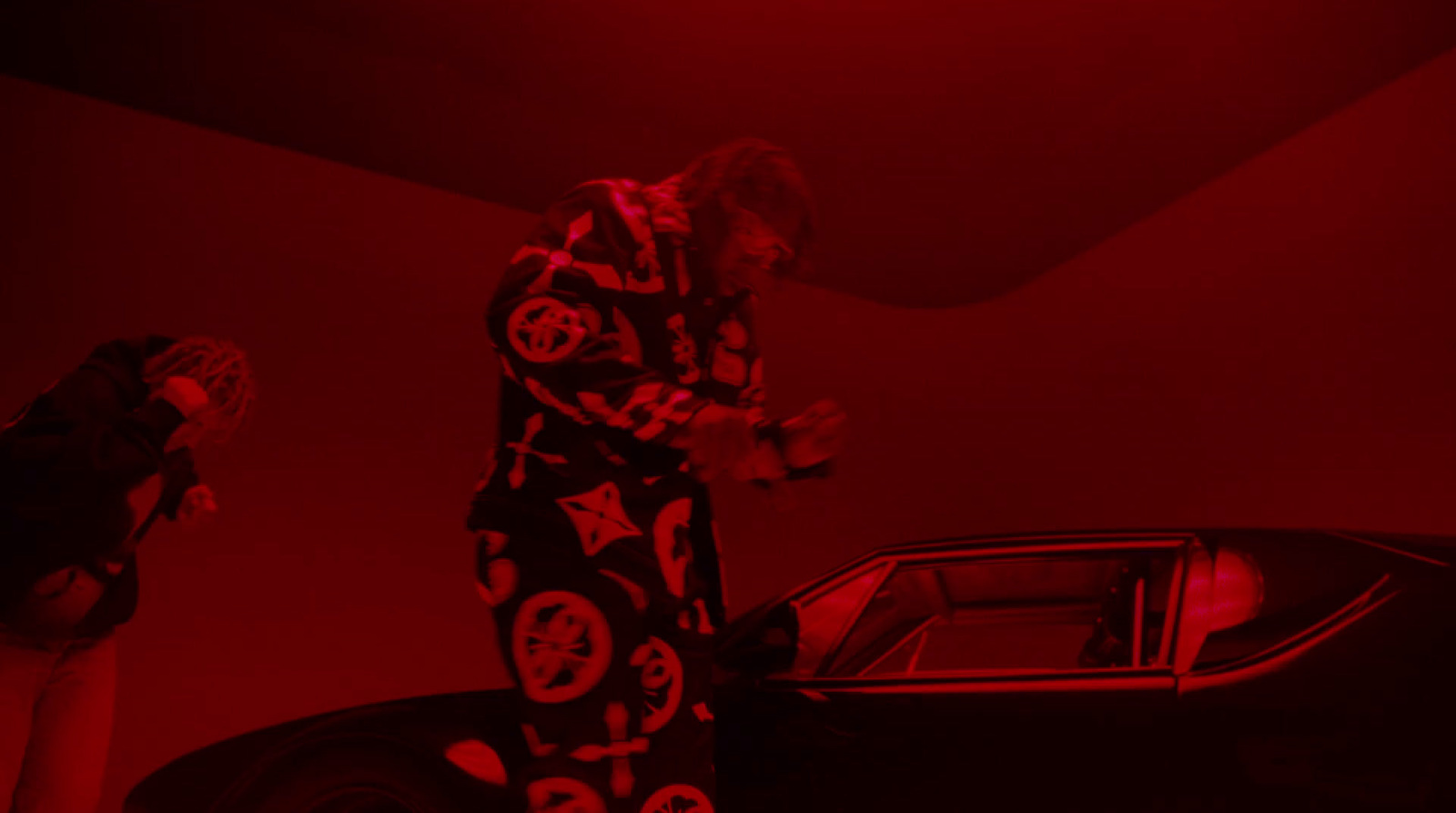 a man standing next to a car in a dark room