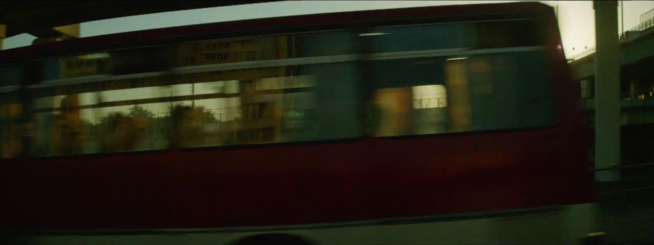 a red double decker bus driving down a street