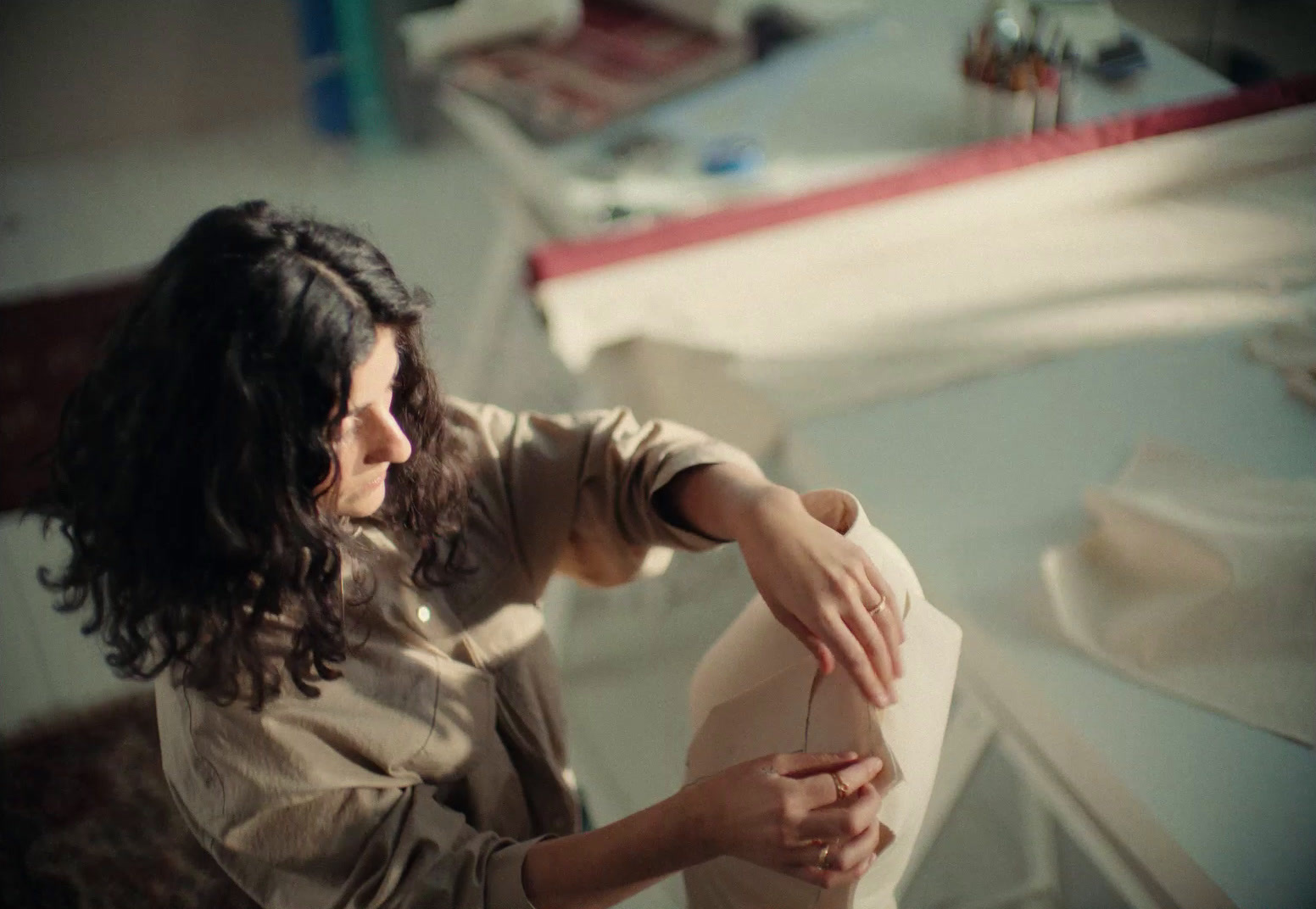 a woman sitting at a table with a sewing machine