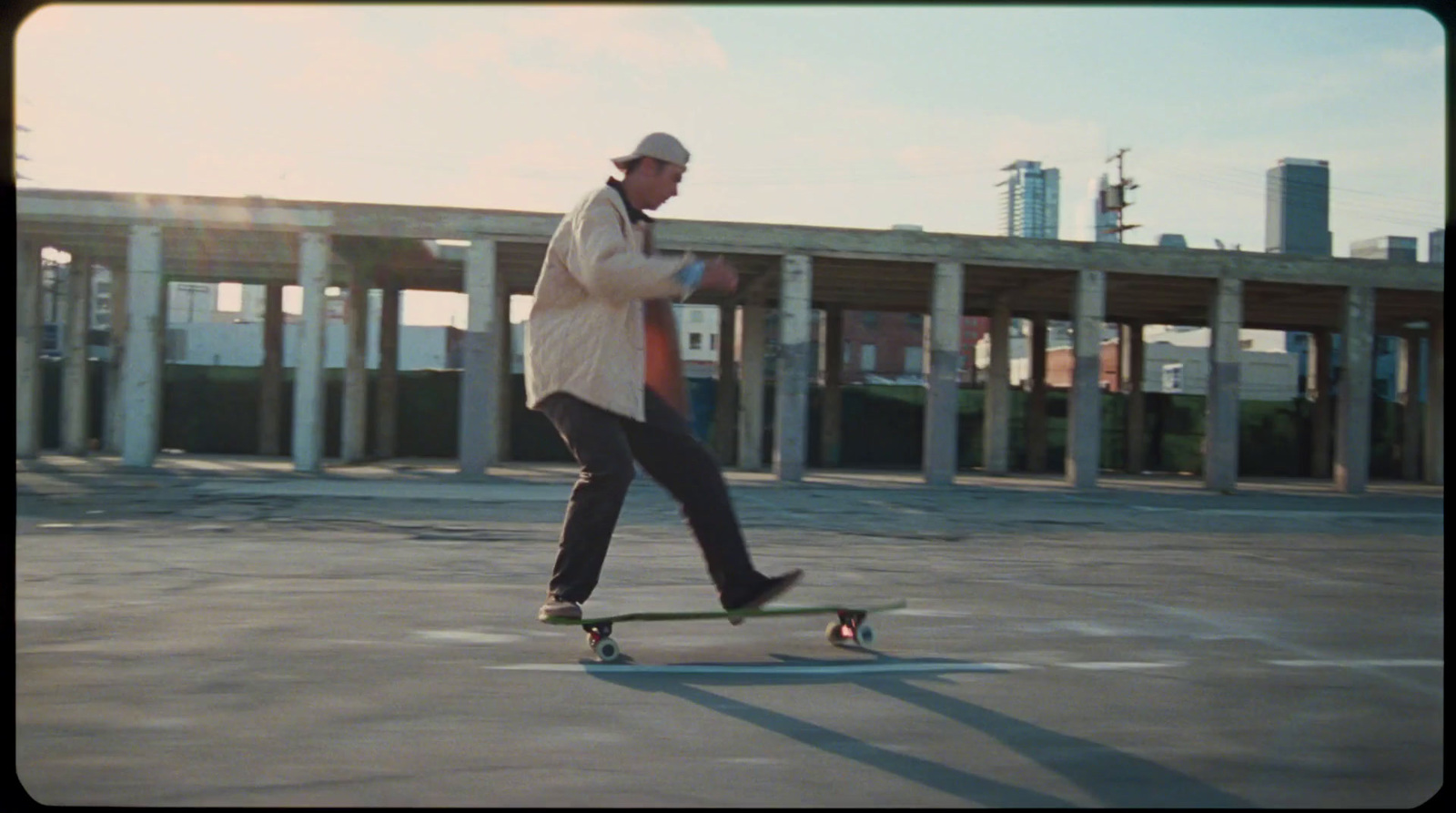 a man riding a skateboard across a parking lot