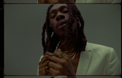 a man with dreadlocks standing in front of a mirror