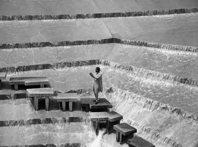 a person standing on a bench in front of a waterfall