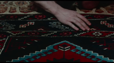 a person is touching a rug on the floor