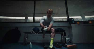 a man sitting on a bench in a locker room