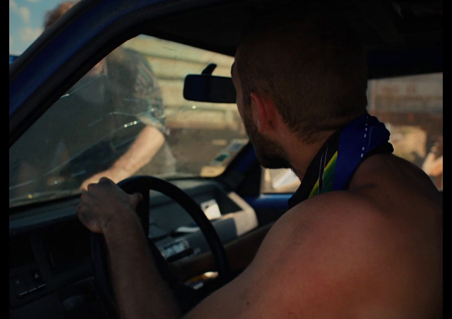 a man driving a car in a parking lot