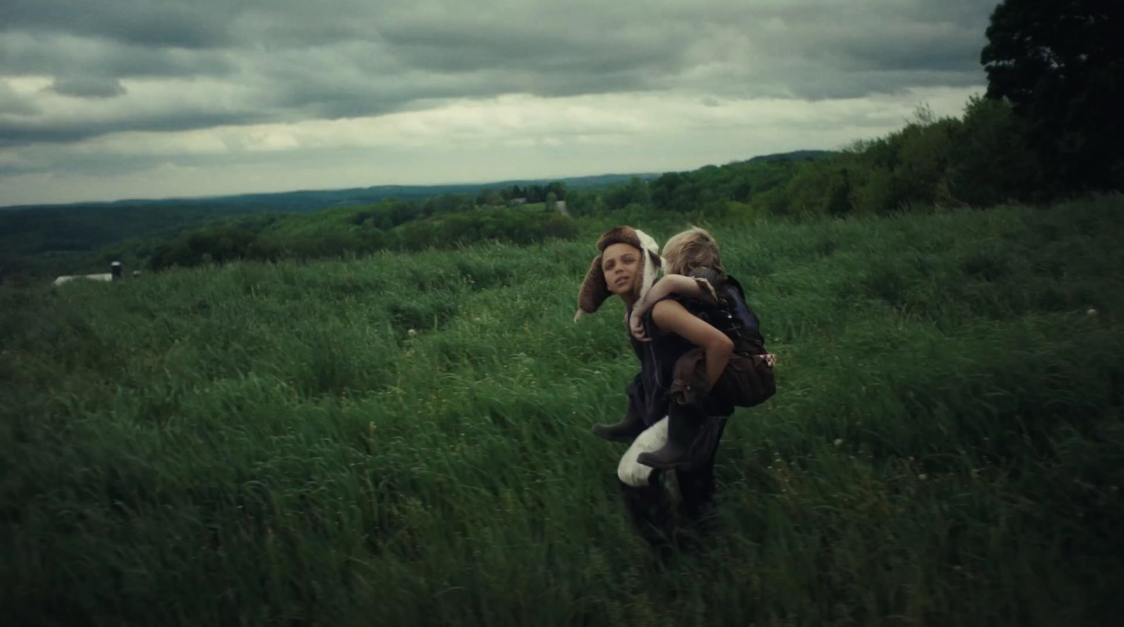 a couple of people walking through a lush green field